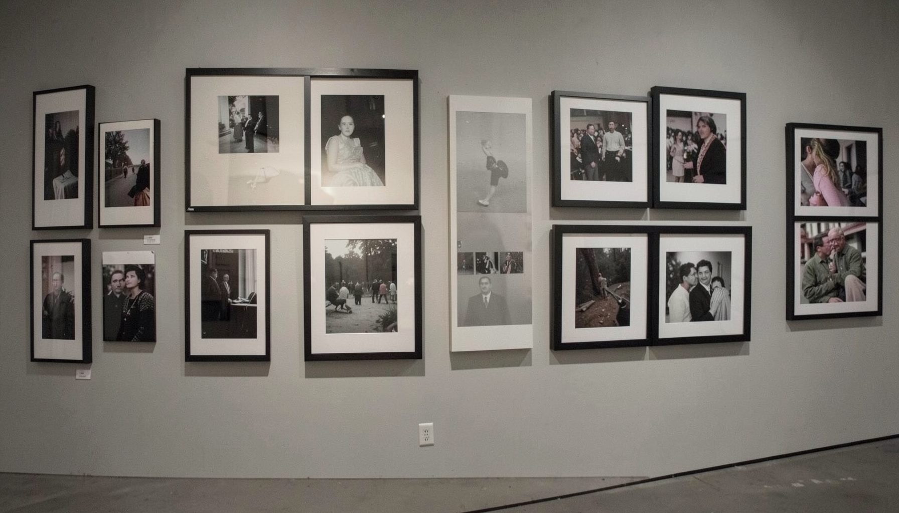 Gallery wall displaying framed photographs in muted gallery light